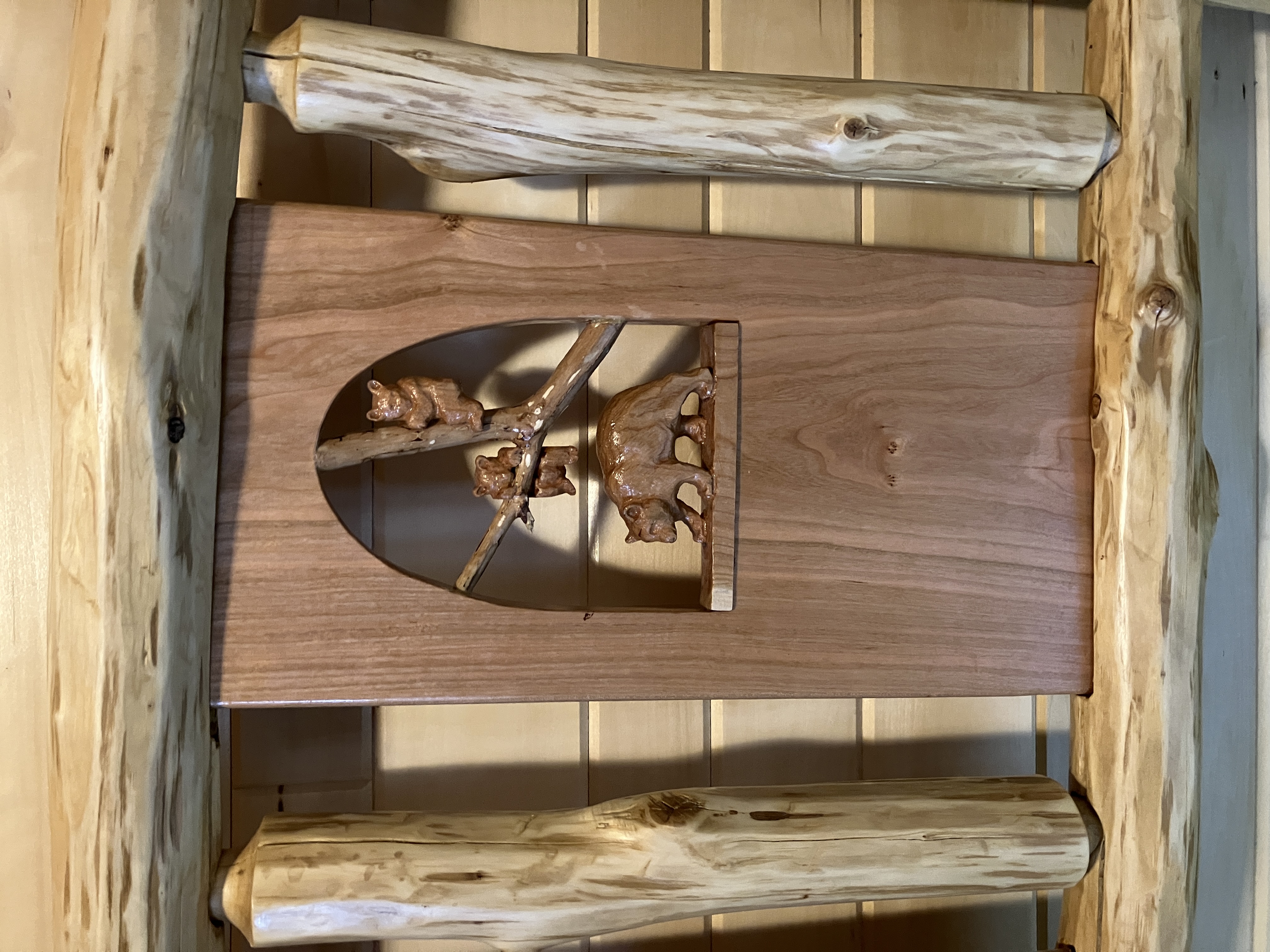 Mother bear and two cubs climbing a tree carved into headboard panel