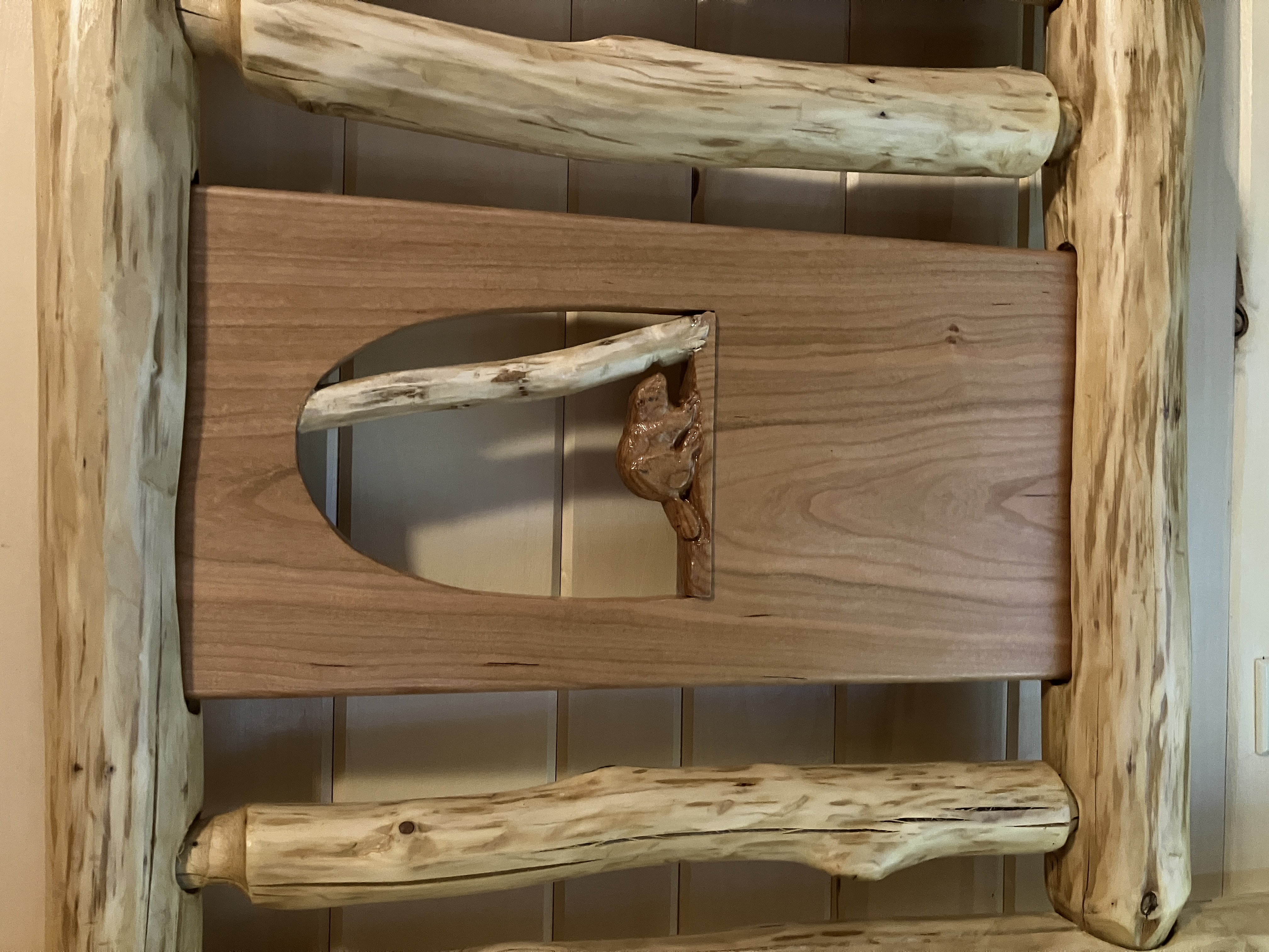 Beaver carving displayed within headboard panel framed by horizontal and vertical logs