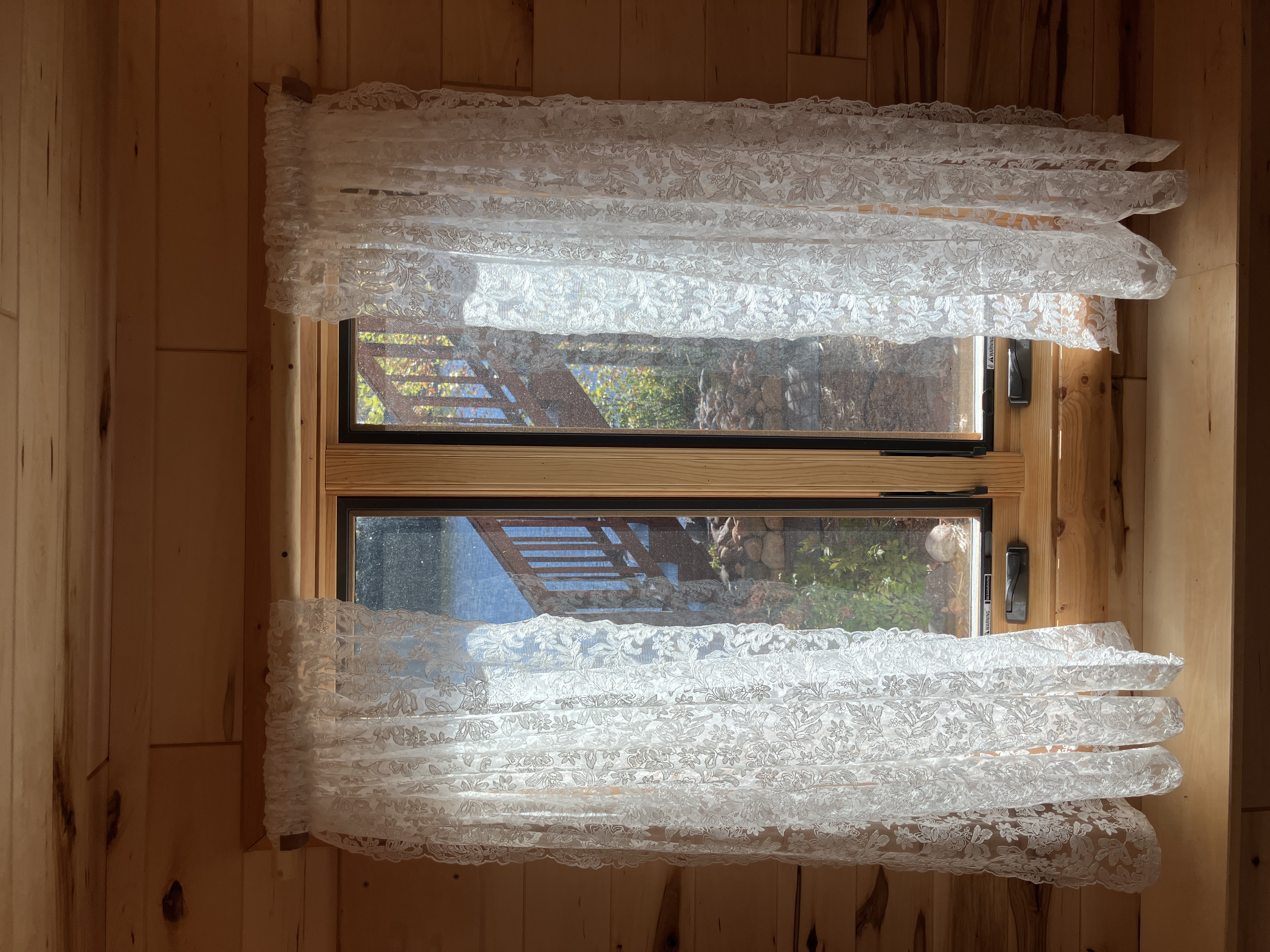 Rustic curtain rod with curtains in cabin window