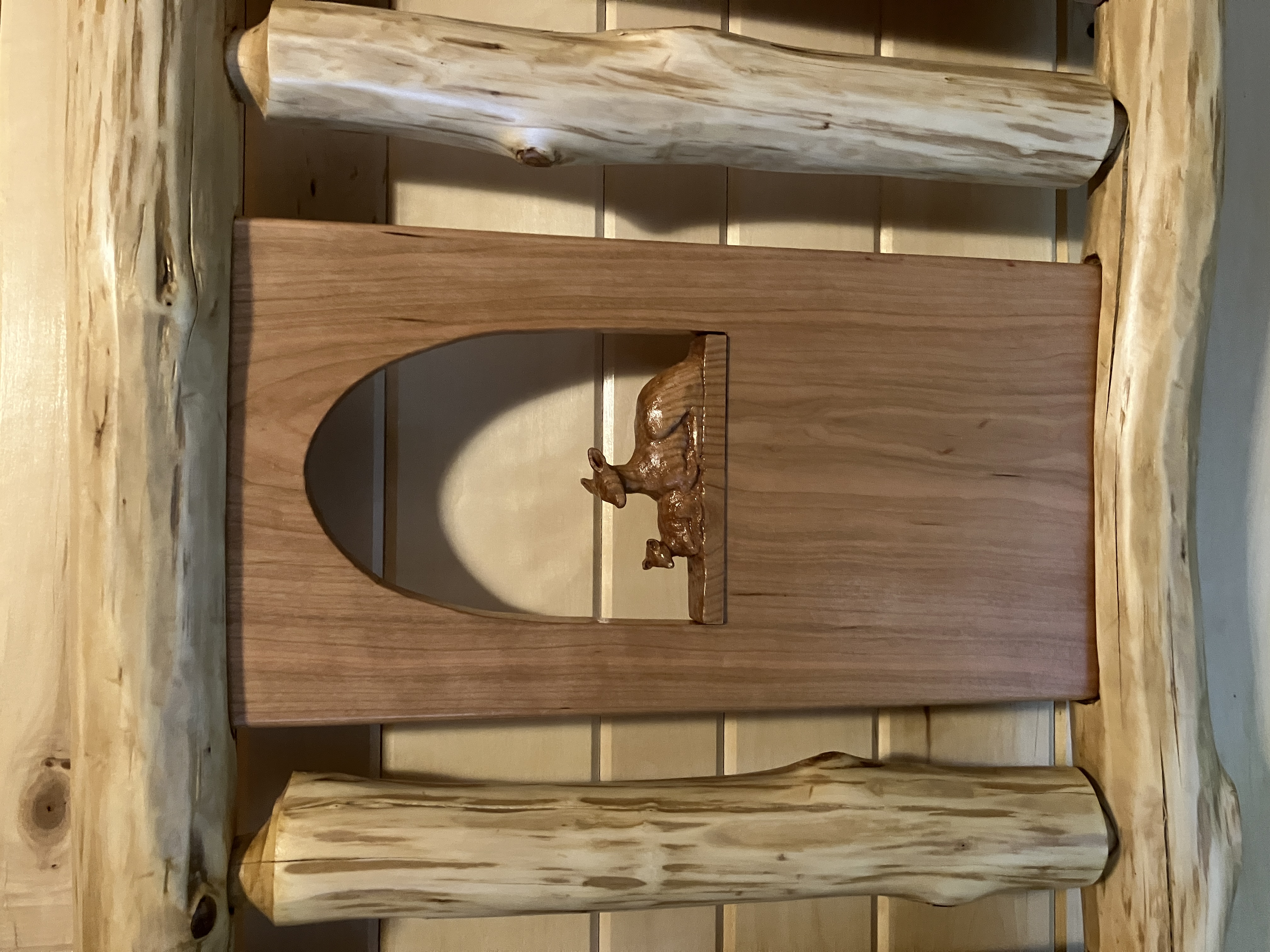 Mother deer and fawn carving within headboard panel framed by horizontal and vertical logs