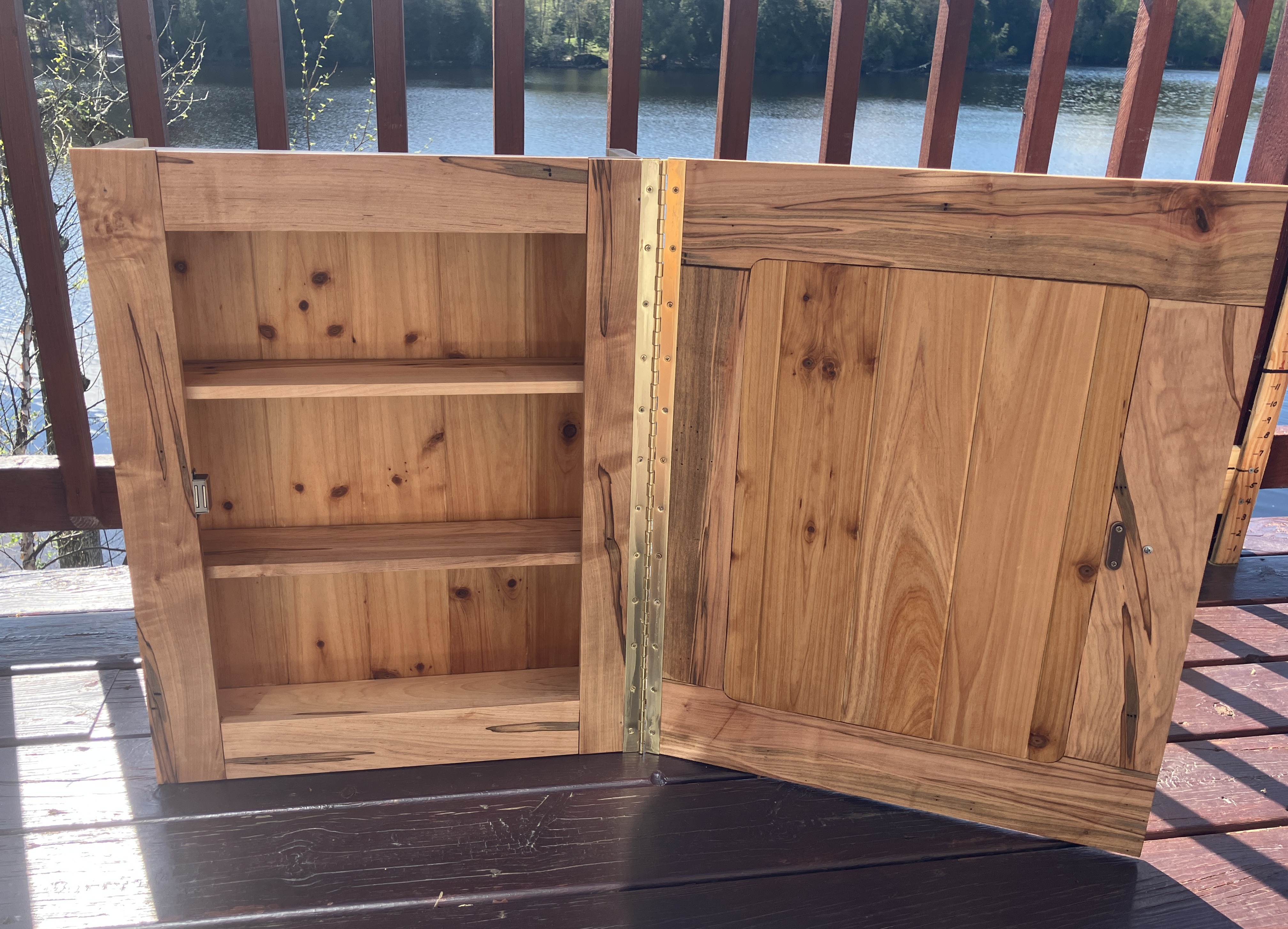 Open rustic medicine cabinet showing handmade shelves and wood grain