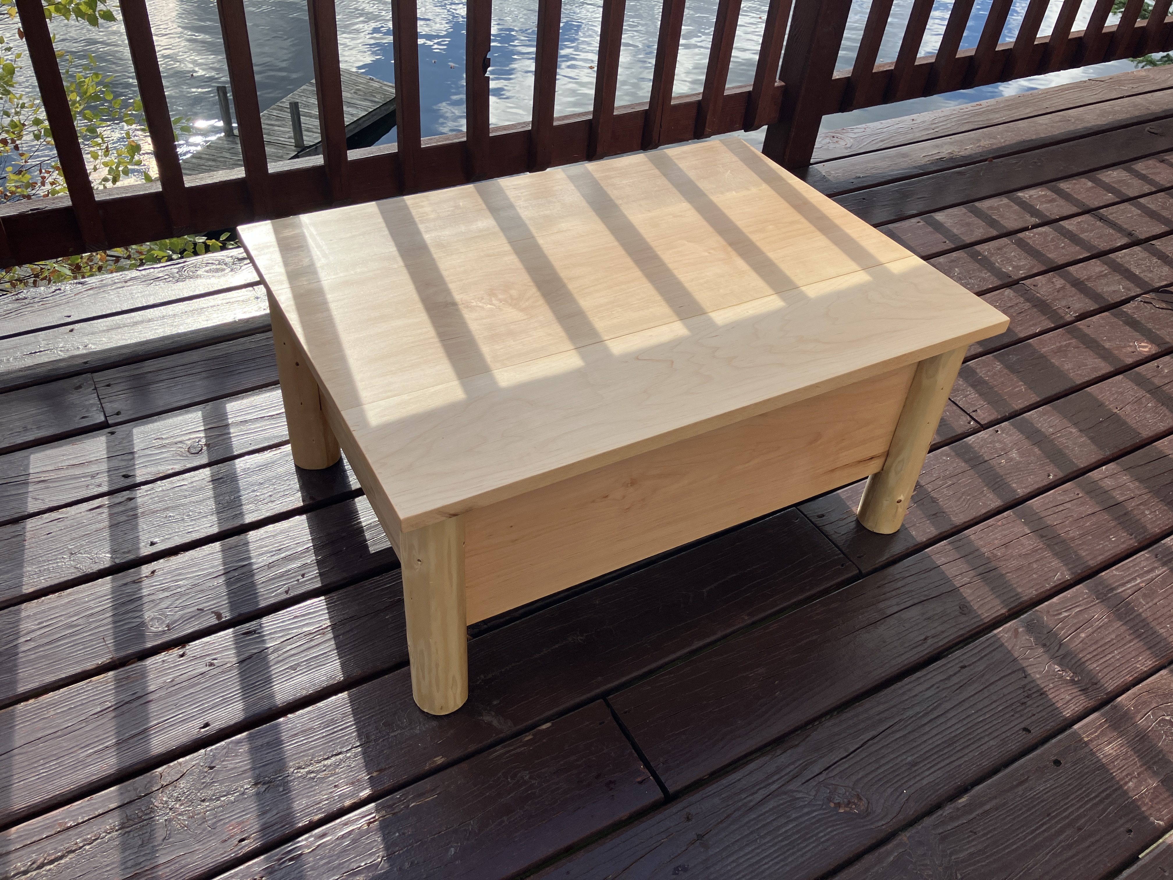 Rustic log ottoman in natural sunlight, viewed from the left side