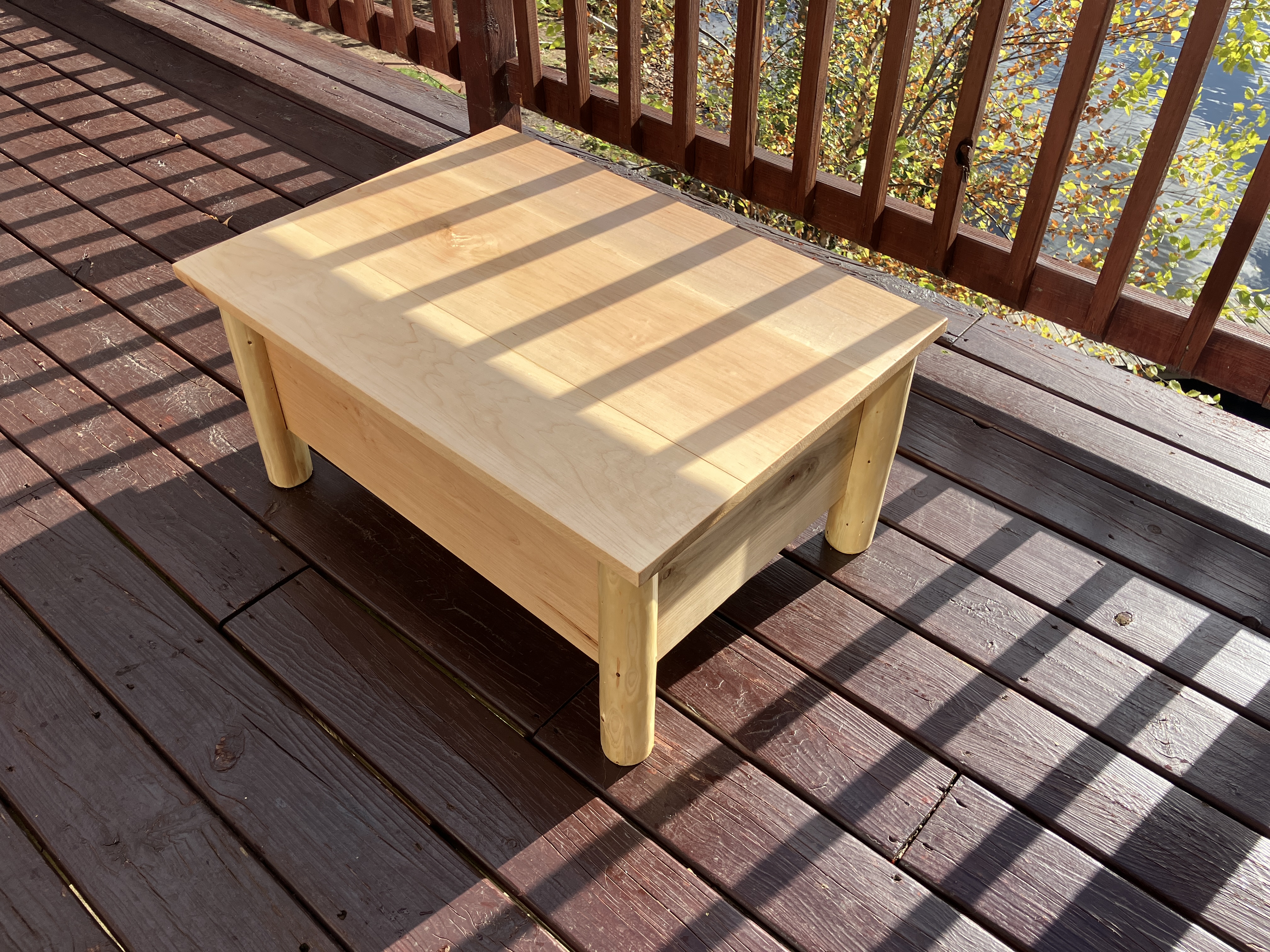 Rustic log ottoman in natural sunlight, viewed from the right side