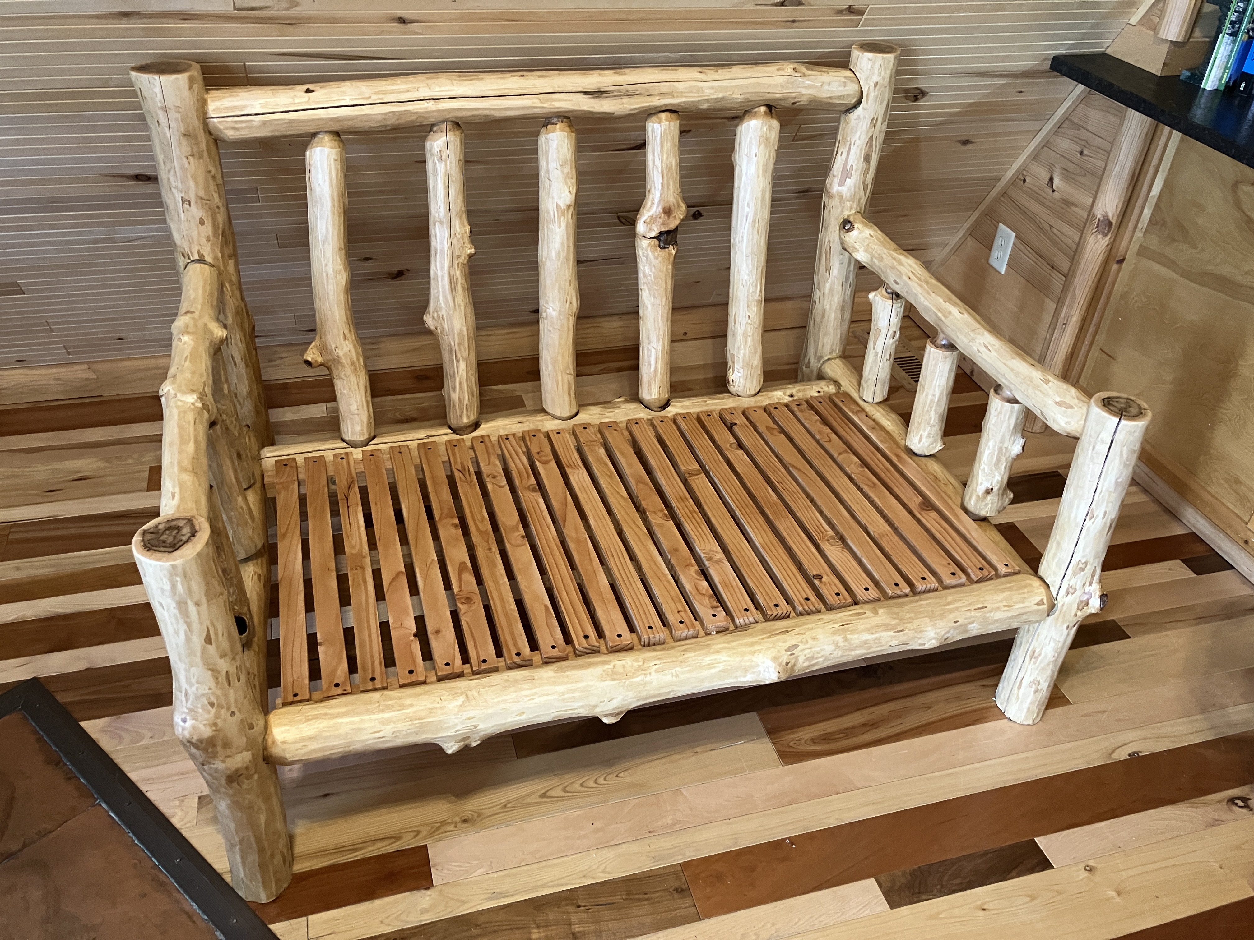 Angle view of log sofa showing armrests and side rails