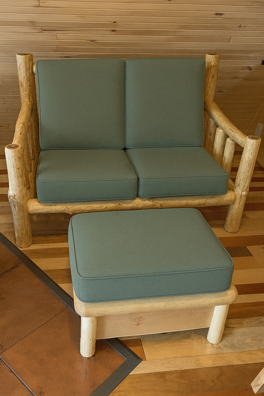 Rustic log sofa and ottoman with forest green cushions