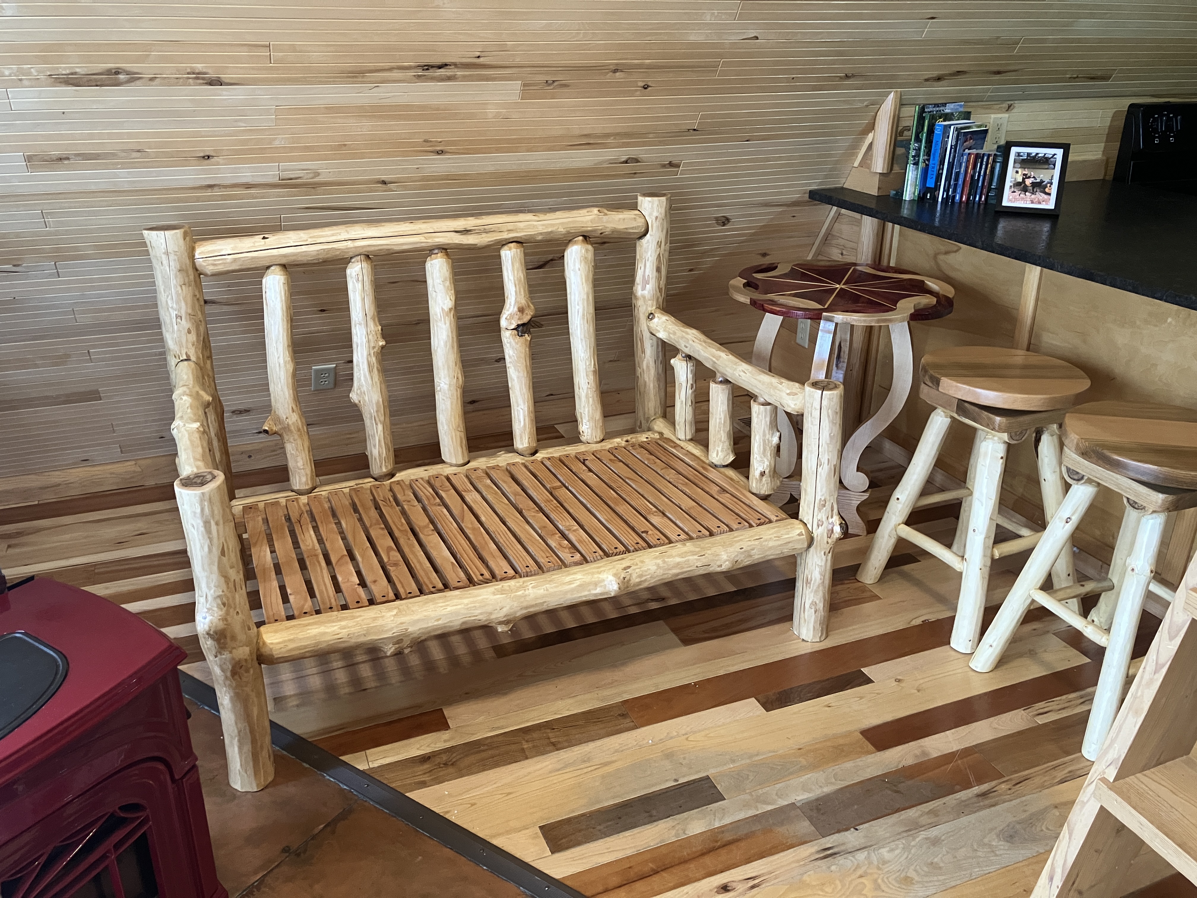 Log sofa, decorative side table, and swivel log stools grouped together