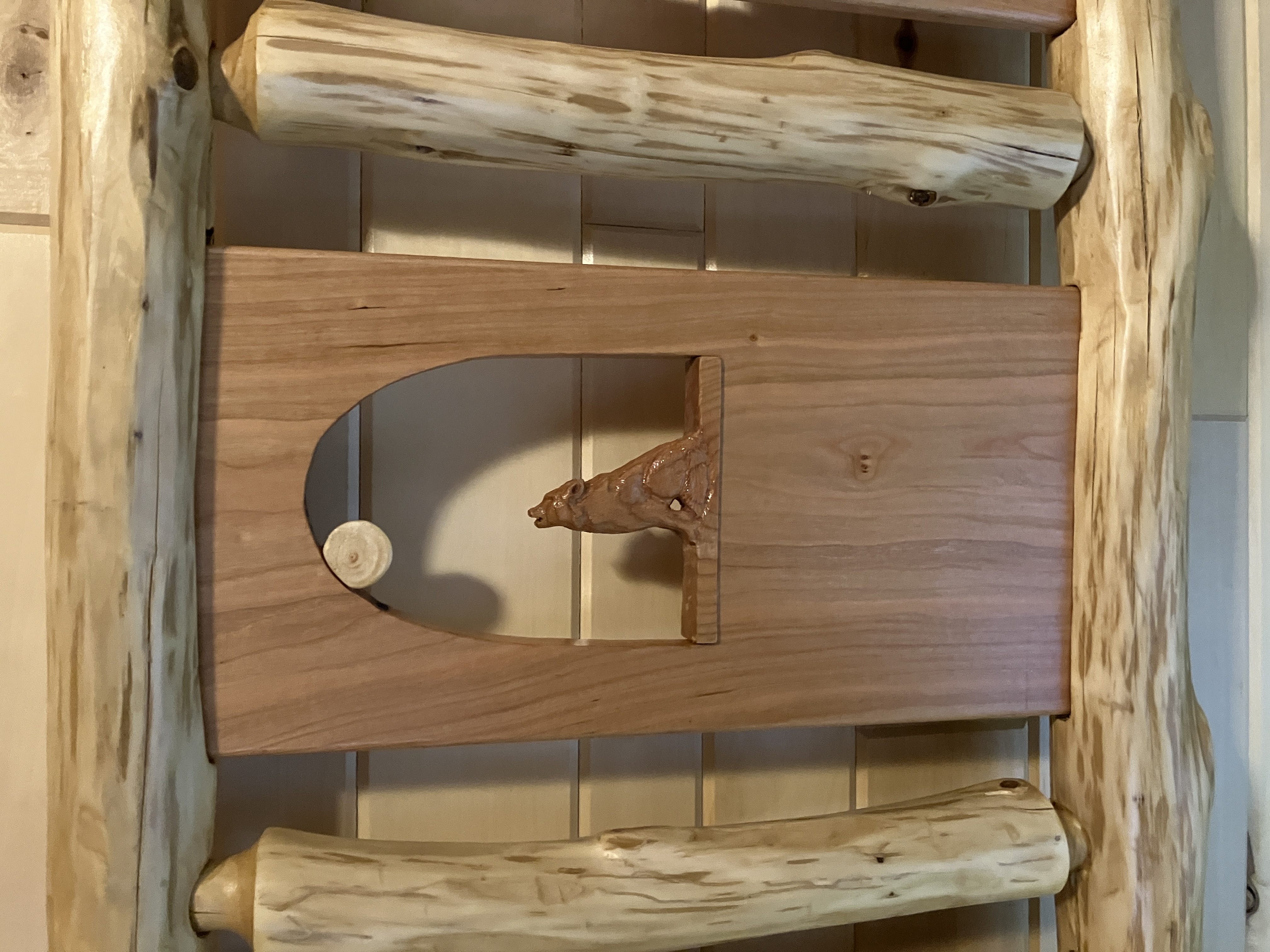 Howling wolf carving within headboard panel framed by horizontal and vertical logs